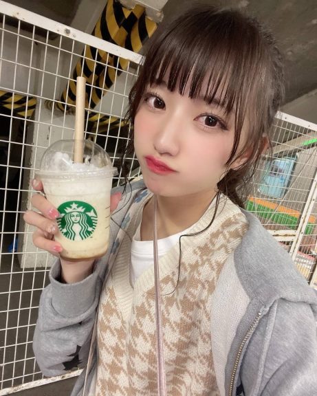 スターバックスのドリンクを持って自撮りをする女性